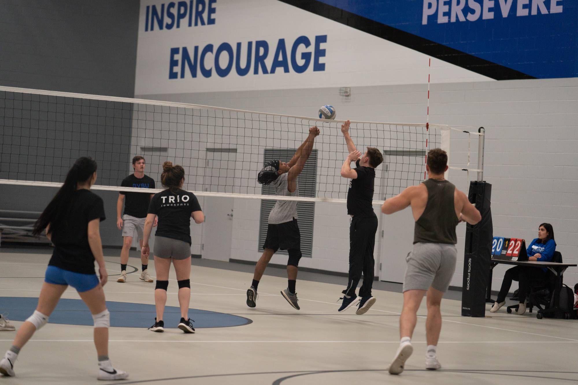 volleyball players playing the ball at the net